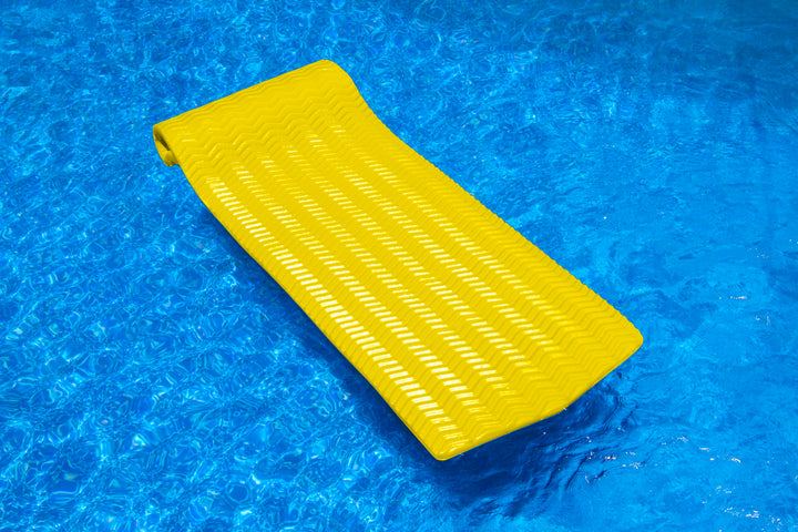 Swimline 74 inch yellow Sofskin floating lounge with 1.5 inch thickness floating on clear blue pool water