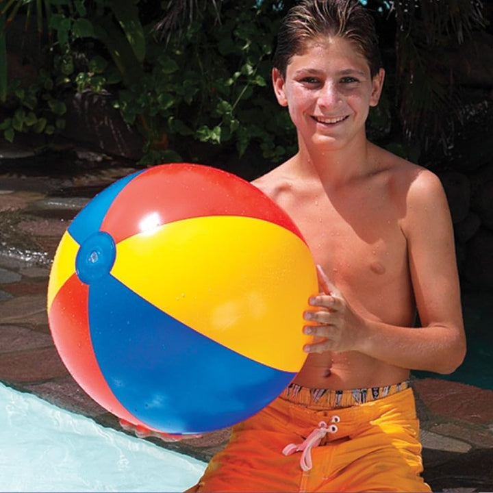 Swimline 24 inch 6 panel beach ball held by a boy wearing orange swim trunks beside a pool showing colorful red yellow and blue panels