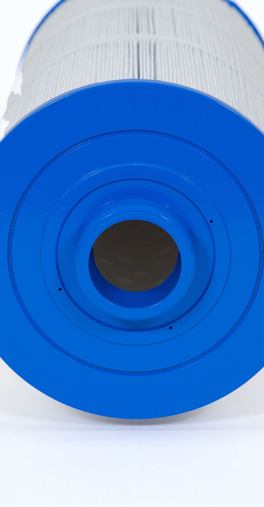 Close-up view of a cylindrical pool filter cartridge with pleated white filtering material and blue plastic end caps