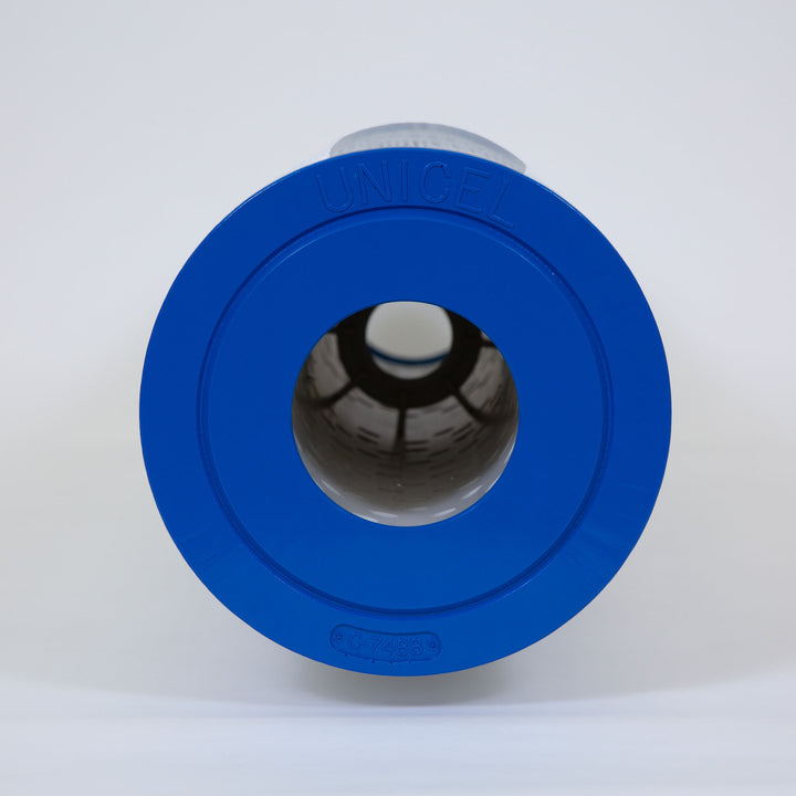 cylindrical pool filter cartridge with blue plastic end caps and pleated white filtering material inside shown from the top view