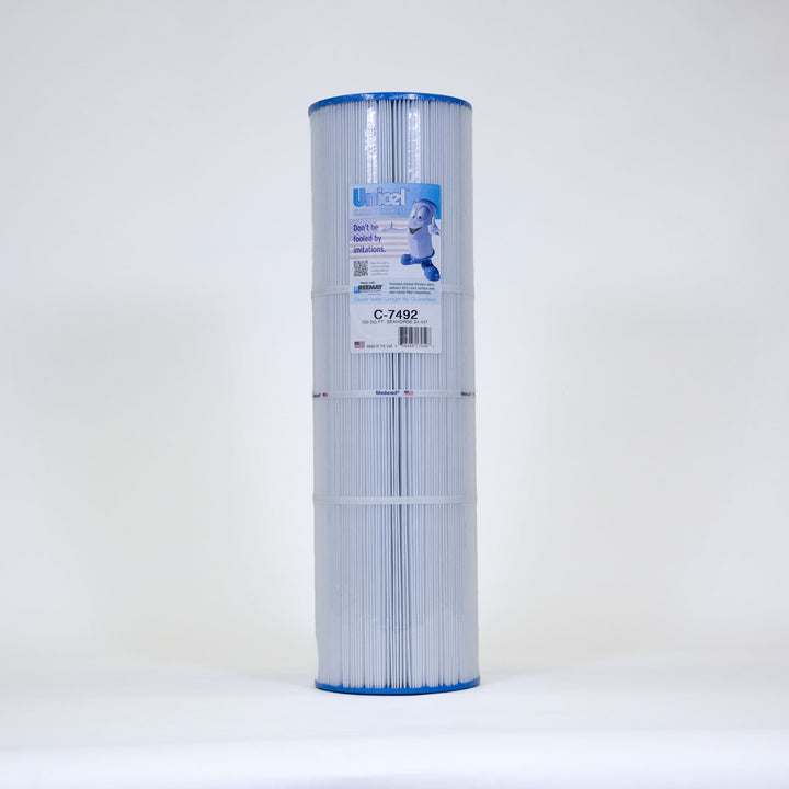 Cylindrical white pool filter cartridge with blue end caps and a label featuring a mascot and product details