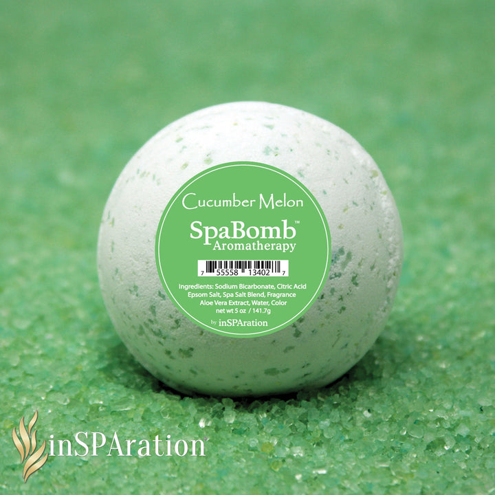 inSPAration SpaBomb Aromatherapy cucumber melon scented bath bomb ball with green speckles on matching green bath salts background