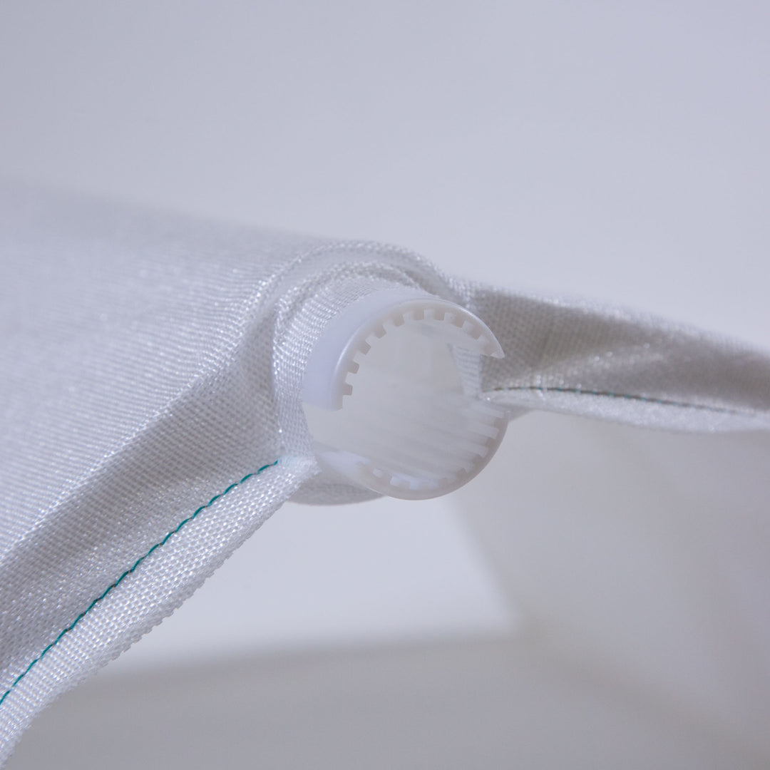 close-up view of white fabric pool filter grid with green stitching and white plastic connector at the end