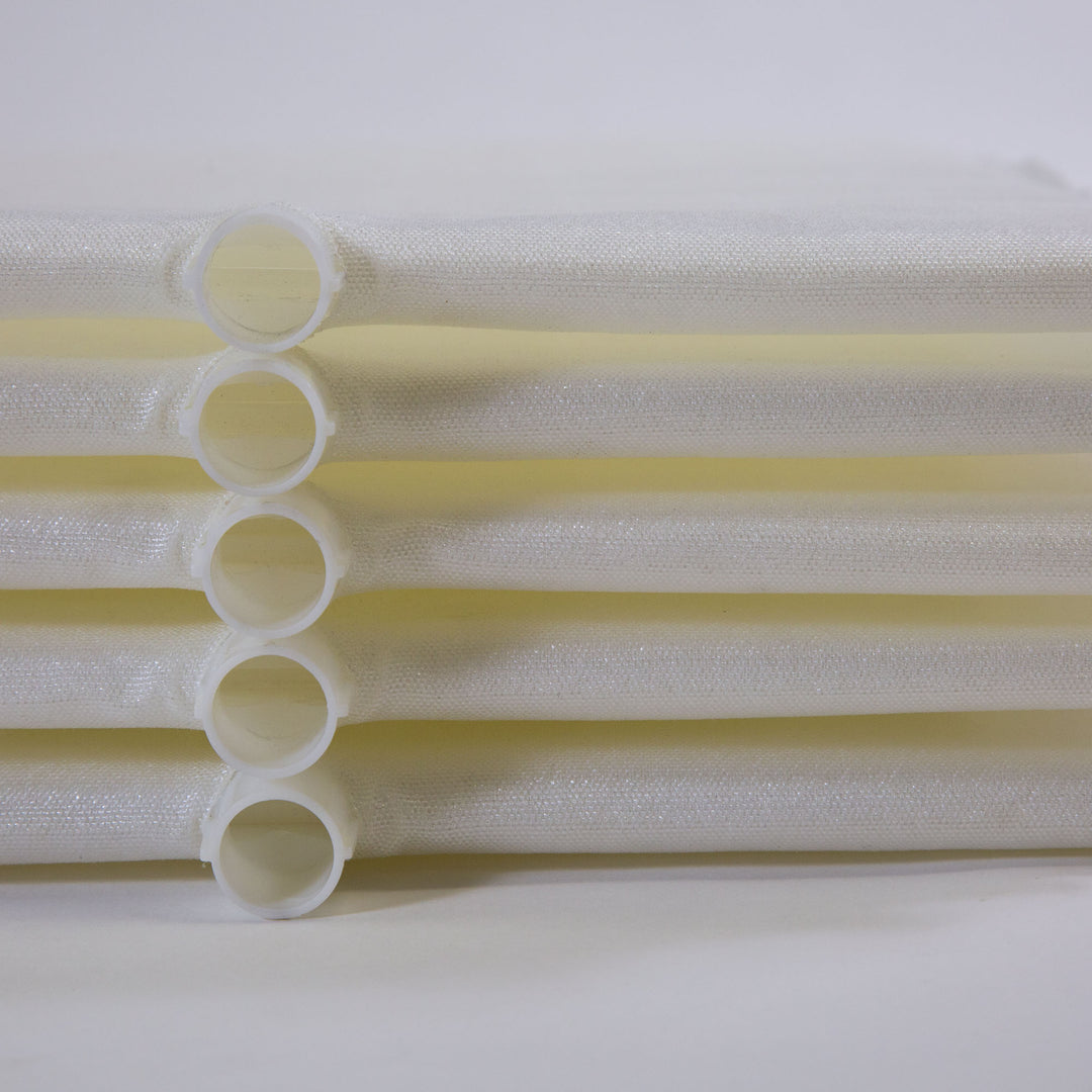 Stack of white cylindrical filter grids with mesh fabric wrapped around plastic frames laid horizontally
