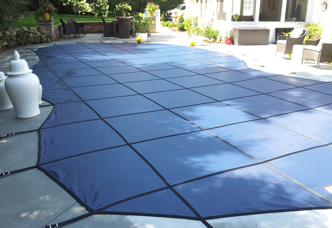 GLI 12 by 24 feet blue rectangle mesh safety cover installed over a rectangular pool with black securing straps visible at the edges