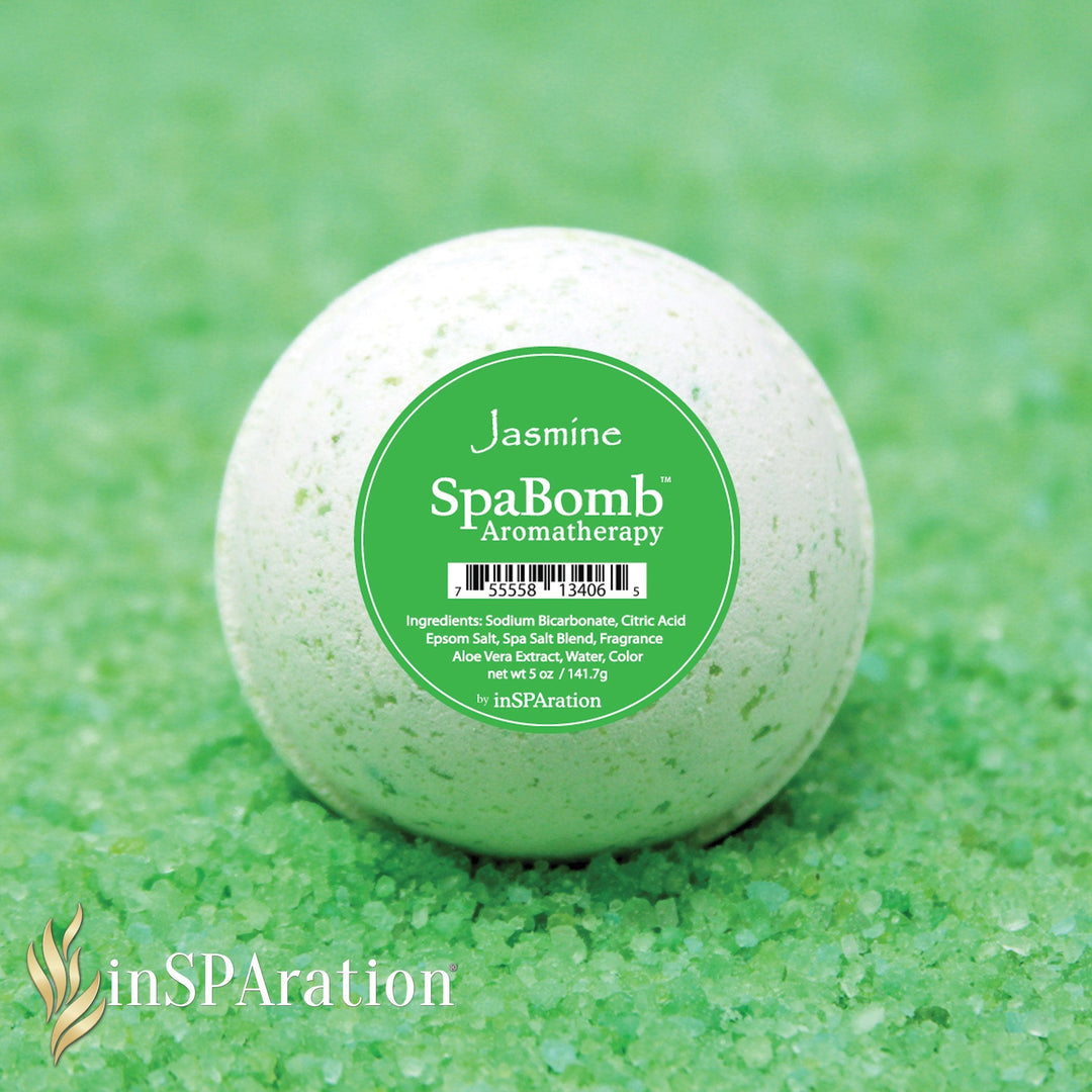 inSPAration SpaBomb Aromatherapy bath bomb in white with green speckles sitting on a bed of green bath salts with green label showing jasmine scent