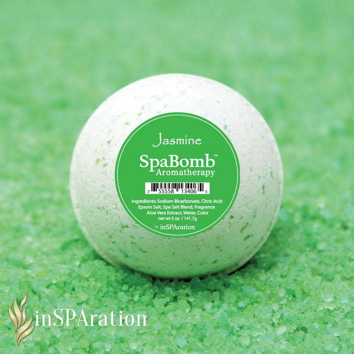 inSPAration SpaBomb Aromatherapy bath bomb in white with green speckles sitting on a bed of green bath salts with green label showing jasmine scent