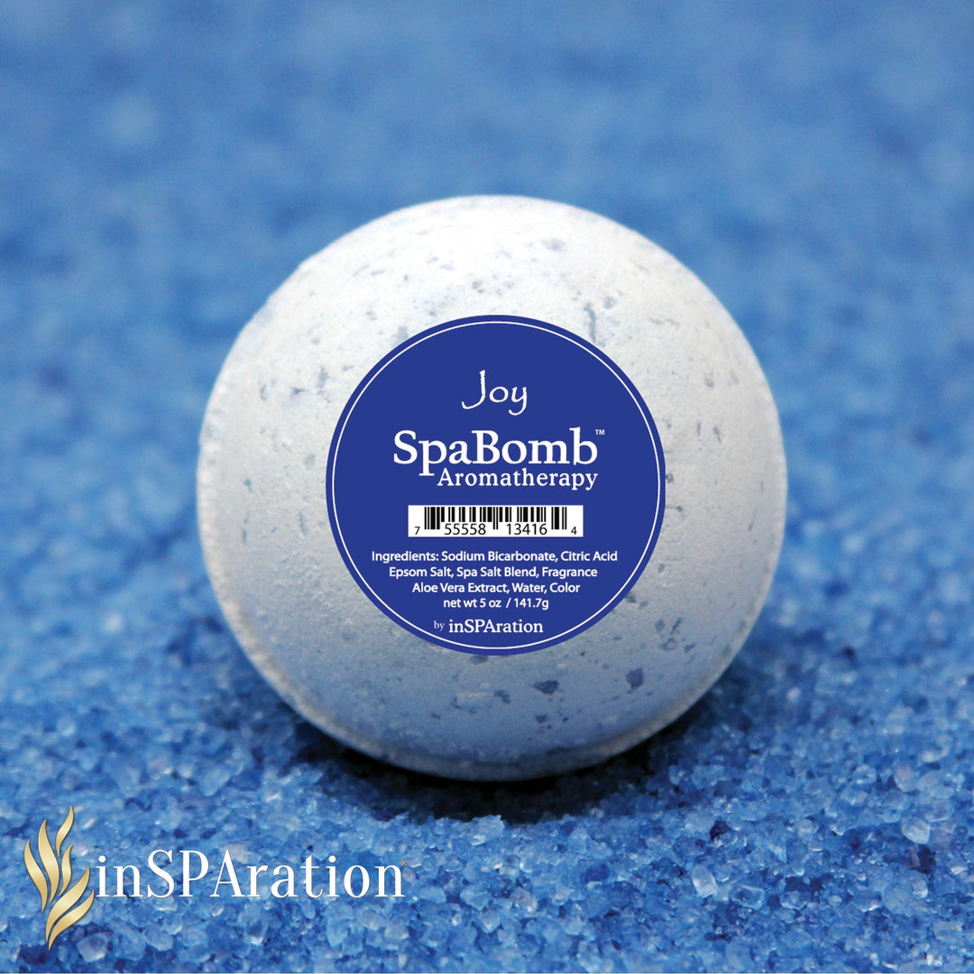 inSPAration SpaBomb Aromatherapy round white bath bomb with blue label on blue granules background