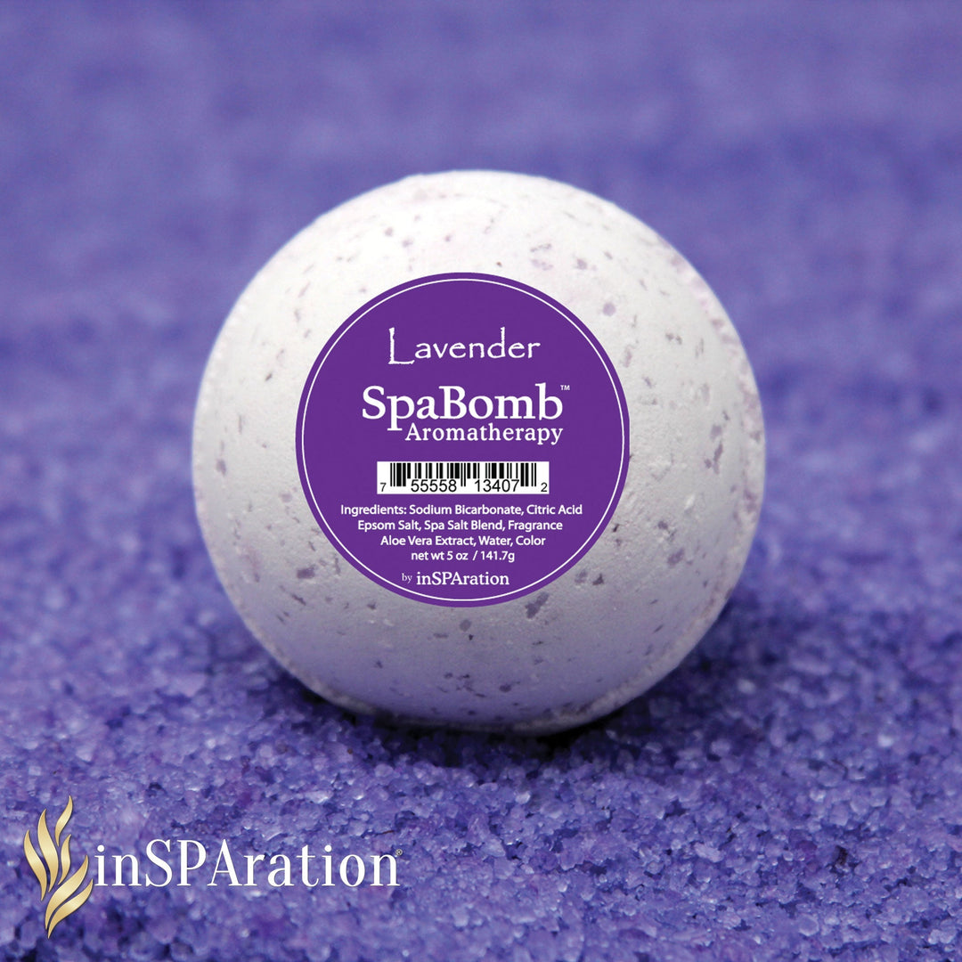 white round inSPAration SpaBomb aromatherapy bath bomb with purple label on a textured purple surface