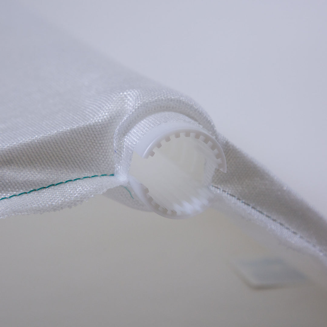 Close-up of a white Unicel DE filter grid with a circular plastic end piece and fine mesh fabric stitched with green thread