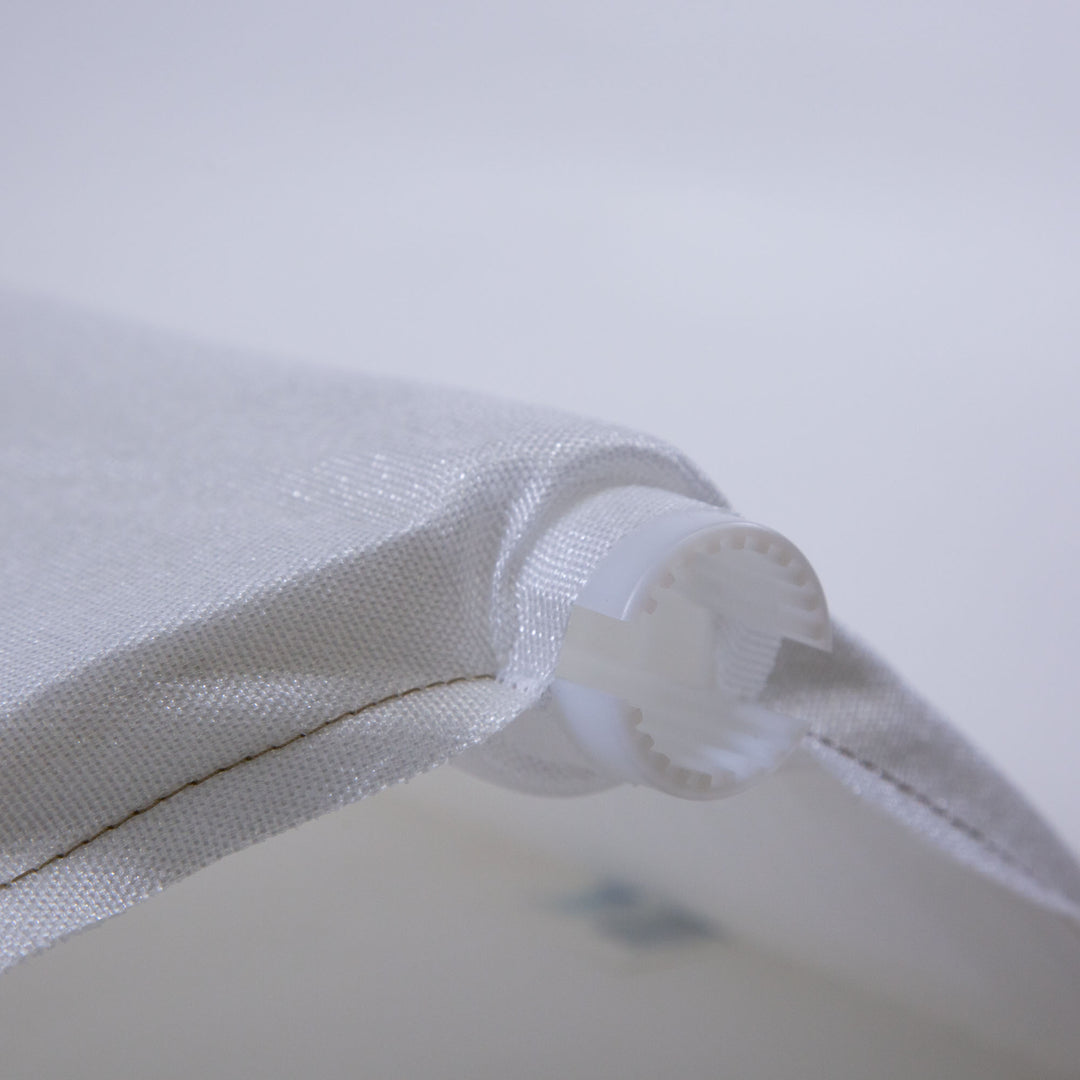 close-up of white woven fabric attached to white plastic gear-like component, used as a pool filter grid