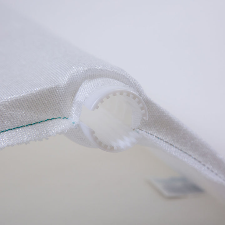 close-up of white mesh pool filter grid fabric with stitched edges and a plastic round connector ring