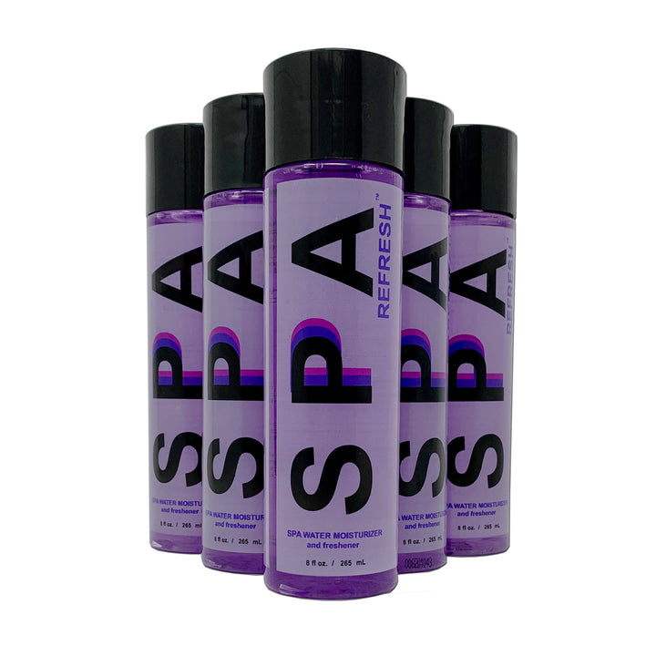 Five purple cylindrical bottles of Spa Refresh spa water moisturizer and freshener with black caps and bold black and purple branding