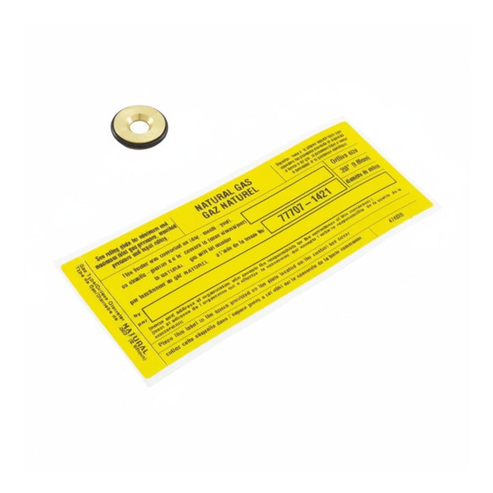 small brass ring with black gasket and yellow rectangular label with black text and barcode on white background