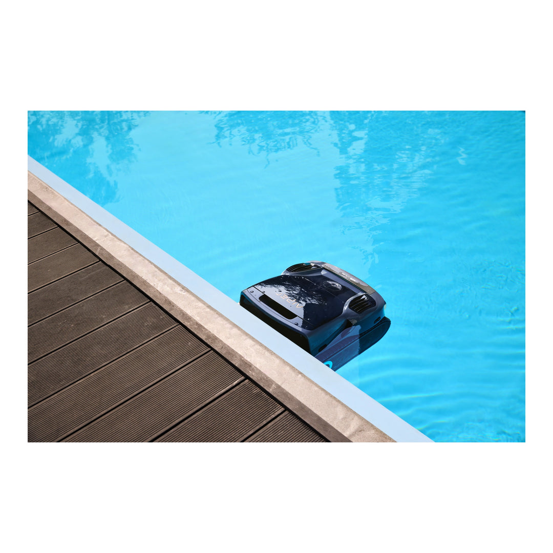 Black Aiper Scuba X1 Pro Max robotic pool cleaner resting against pool edge, partially submerged in blue water.