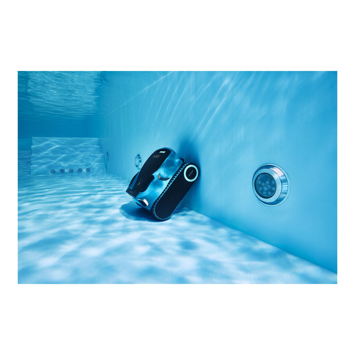 Black and blue Aiper Scuba X1 Pro Max cordless robotic pool cleaner submerged, climbing a pool wall underwater.