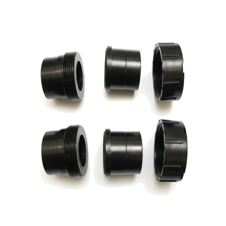 Six black cylindrical plumbing components including threaded union and buttress parts arranged on white background